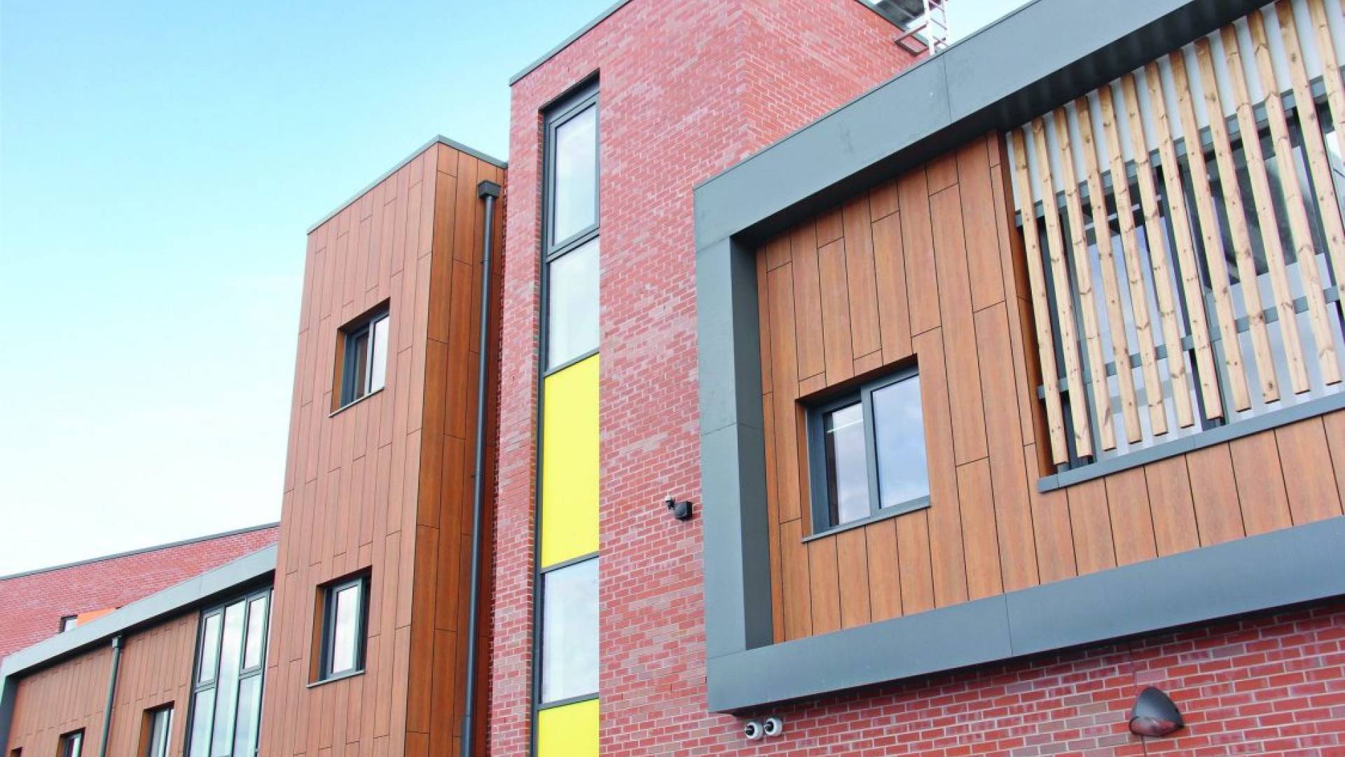 Detailed shot of hospotal exterior, showing brick and wood panels